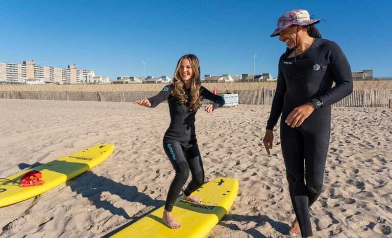 Newsday travel writer Carissa Kellman gets a surfing lesson from...