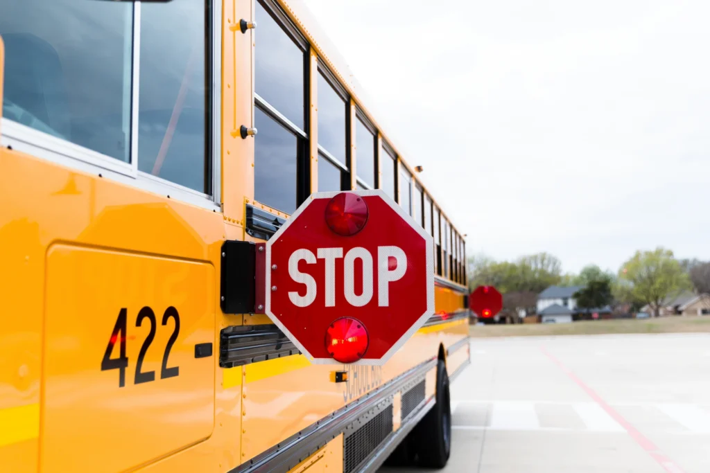 Yellow school bus with stop sign deployed. Safety, transportation, education.